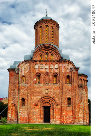 Nature frames the Pyatnitskaya Church beautifully in this scene, with its red brick facade, prominent dome, and cross, a clear and open sky, a medieval brick church in Chernihiv. Nature frames the Pyatnitskaya Church beautifully in this scene, with its red brick facade, prominent dome, and cross, a clear and open sky, a medieval brick church in Chernihiv. 109148047
