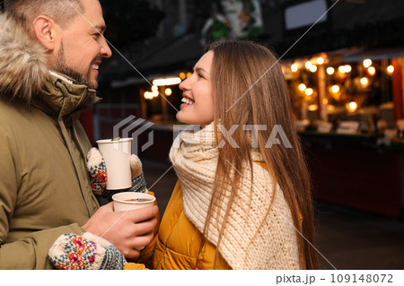 Happy couple with mulled wine at winter fair Happy couple with mulled wine at winter fair 109148072