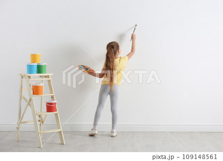 Little child painting on blank white wall indoors 109148561