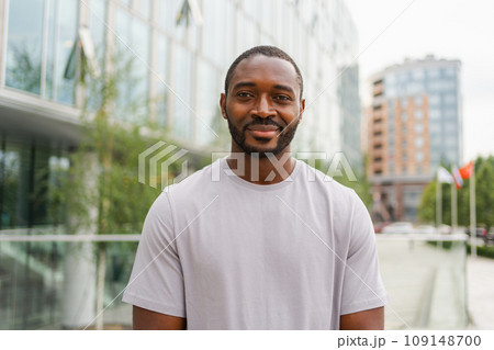 Happy african american man smiling outdoor. Portrait of young happy man on street in city. Cheerful joyful handsome person guy looking at camera. Freedom happiness carefree happy people concept 109148700
