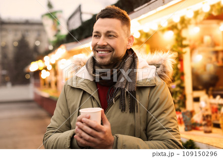 Happy man with mulled wine at winter fair 109150296