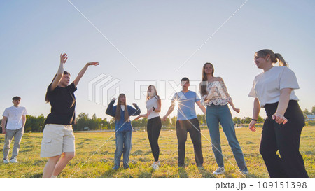 Funny jolly friends dancing in the city meadow in the evening. Funny jolly friends dancing in the city meadow in the evening. 109151398