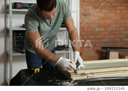Man repairing old damaged window at table indoors Man repairing old damaged window at table indoors 109152140
