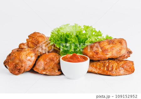 Chicken wings fried until half cooked, semi-finished product with fresh herbs on a white background. Fast food. Quick cooking at home. Copy space.Fast cooking.Fast homemade food. Chicken wings fried until half cooked, semi-finished product with fresh herbs on a white background. Fast food. Quick cooking at home. Copy space.Fast cooking.Fast homemade food. 109152952
