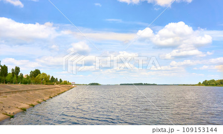 Stone river embankment overgrown with green bushes Stone river embankment overgrown with green bushes 109153144