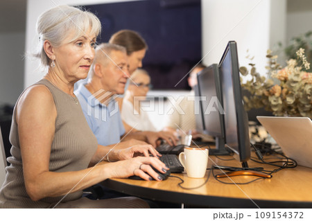 Elderly woman studying at computer course in group Elderly woman studying at computer course in group 109154372