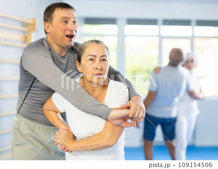 Old woman practicing self-defense techniques in pairs 109154506