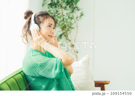 部屋で音楽を聴く若い女性 部屋で音楽を聴く若い女性 109154550