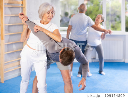 Old woman twisting her opponent's arm during self-defense classes Old woman twisting her opponent's arm during self-defense classes 109154809