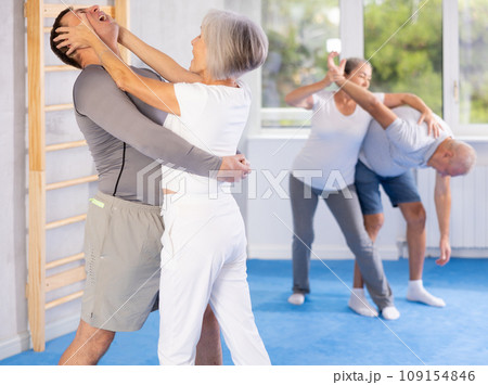 Old woman practicing self-defense techniques in pairs 109154846