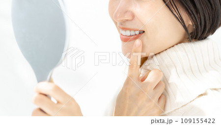 鏡で歯を確認する女性 鏡で歯を確認する女性 109155422