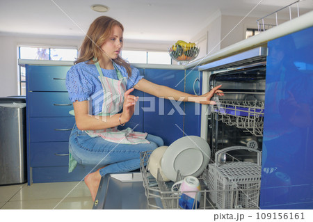 食器洗浄機に食器を入れる白人女性 109156161