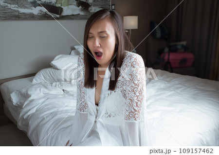 The woman woke up and yawned in the early morning. 109157462