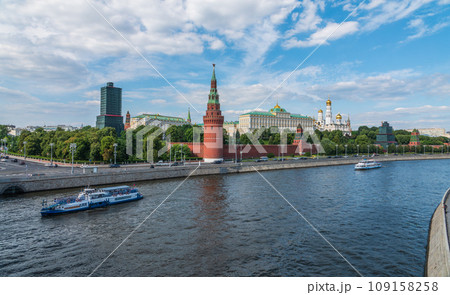 View of Kremlin with Vodovzvodnaya tower, Grand Kremlin Palace from repaired Bolshoy Kamenny Bridge in Moscow city on sunny summer day. Cruise ship sails on the Moscow river 109158258