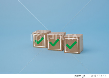 Wood cube with a check mark on background. Checklist concept list, vote, questionnaire, survey select the check list. Wood cube with a check mark on background. Checklist concept list, vote, questionnaire, survey select the check list. 109158366