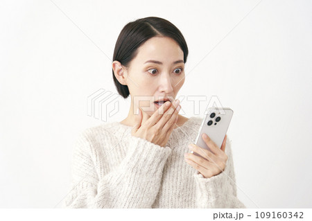 スマホを見て驚くミドルエイジの女性　白背景 109160342