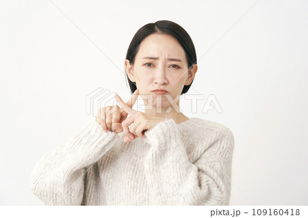 指でばつ印のジェスチャーをするミドルエイジの女性 白背景 指でばつ印のジェスチャーをするミドルエイジの女性 白背景 109160418