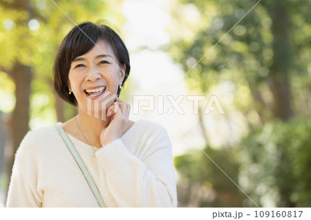 公園を散歩する50代の女性 公園を散歩する50代の女性 109160817