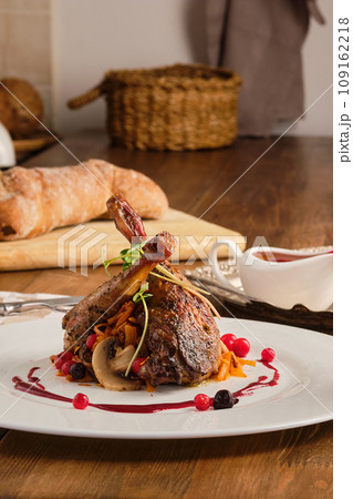 Plate with baked partridge thigh with cranberry sauce Plate with baked partridge thigh with cranberry sauce 109162218