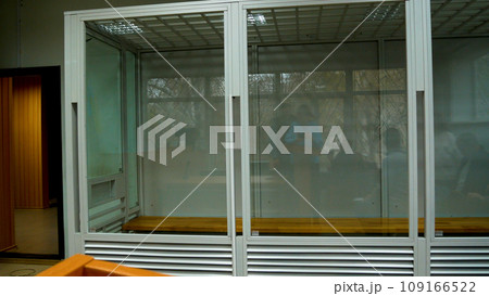 A cage with bulletproof glass for a suspect imprisoned in a courtroom. Panorama. A cage with bulletproof glass for a suspect imprisoned in a courtroom. Panorama. 109166522