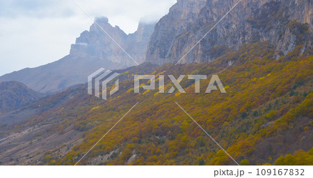 Cloudy foggy sky, mountain peaks covered with fog in the morning. Caucasus Mountains, Russia. Cloudy foggy sky, mountain peaks covered with fog in the morning. Caucasus Mountains, Russia. 109167832