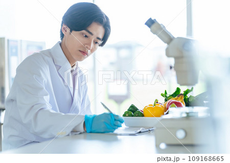 顕微鏡で野菜の成分を観察する若い研究者　管理栄養士 109168665