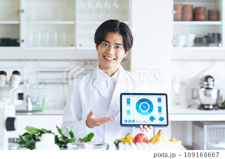 タブレットで画面を見せながら説明する研究者 109168667