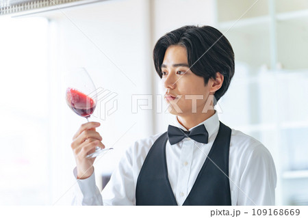 ワイングラスを見つめる男性　ソムリエ　ワインエキスパート 109168669
