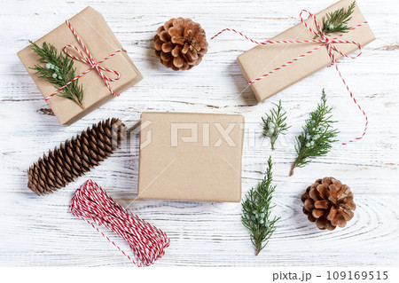 Christmas background with hand crafted gifts, presents on rustic wooden table. Christmas or New year DIY packing. Holiday decor concept. Overhead, flat lay, top view 109169515