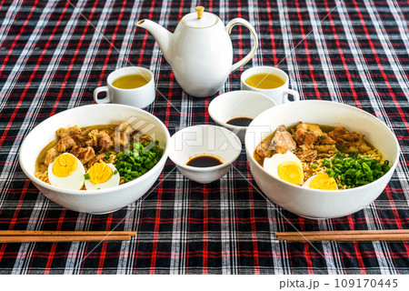 Japanese ramen with chicken and soy sauce on the table with teapot and green tea 109170445