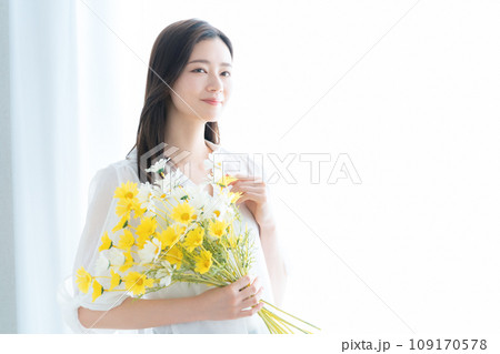 リビングで花束を持つ若い女性 リビングで花束を持つ若い女性 109170578