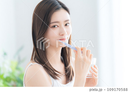 リビングでソファに座って歯磨きをする若い女性 リビングでソファに座って歯磨きをする若い女性 109170588
