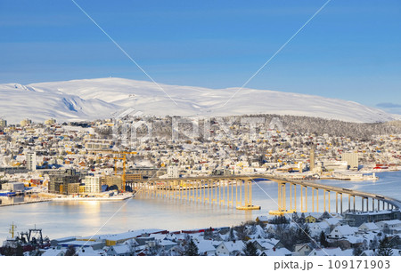 Snowy roofs, embankment near the port and fishing ships, Sunny winter day. Snowy roofs, embankment near the port and fishing ships, Sunny winter day. 109171903
