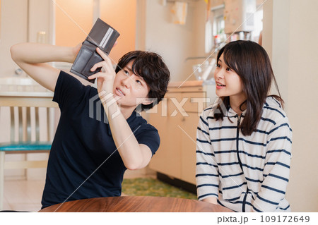 お金がなくて苦しむ若い夫婦 109172649