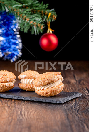 Coconut cookies with cream on a mica serving board and blurred New Year's background. Coconut cookies with cream on a mica serving board and blurred New Year's background. 109172979