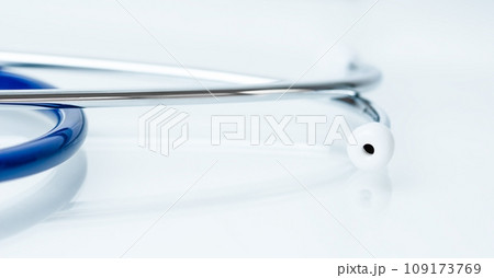 Close-up of a stethoscope on a light blue table. 109173769