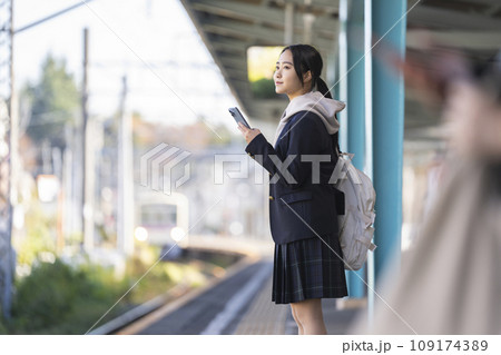 ホームで電車を待つスマホを持った女子学生 撮影協力「京王電鉄株式会社」 ホームで電車を待つスマホを持った女子学生 撮影協力「京王電鉄株式会社」 109174389