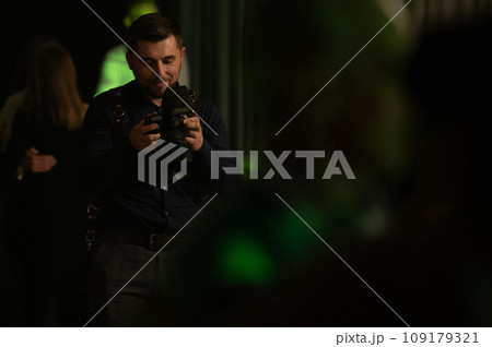 A photographer at work, the process of shooting and photographing celebrations. Paparazzi conducts a journalistic investigation at a party. A photographer at work, the process of shooting and photographing celebrations. Paparazzi conducts a journalistic investigation at a party. 109179321