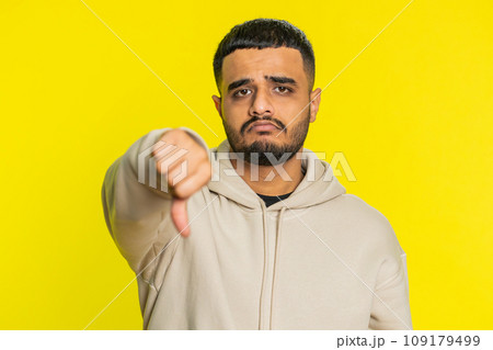 Upset man guy showing thumbs down gesture disapproval dissatisfied dislike negative feedback Upset man guy showing thumbs down gesture disapproval dissatisfied dislike negative feedback 109179499