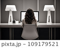 young woman working from home in front of a computer monitor. The apartment is minimalistic 109179521