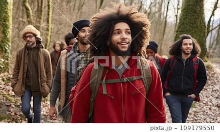 Cheerful group of friends with backpacks for hike walking through autumn forest exploring nature. 109179550