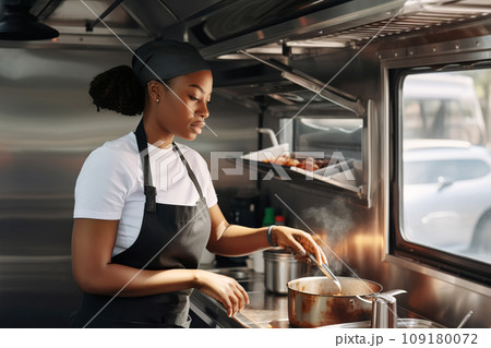 African American female chef preparing takeaway food in food truck kitchen African American female chef preparing takeaway food in food truck kitchen 109180072