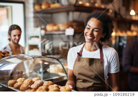 Attractive female seller puts fresh pastries on display and sells them to customers Attractive female seller puts fresh pastries on display and sells them to customers 109180219