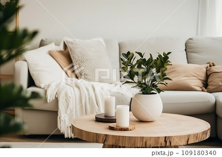 Minimal living room with Round wooden coffee table near sofa close-up. Natural interior decor and biophilic design 109180340