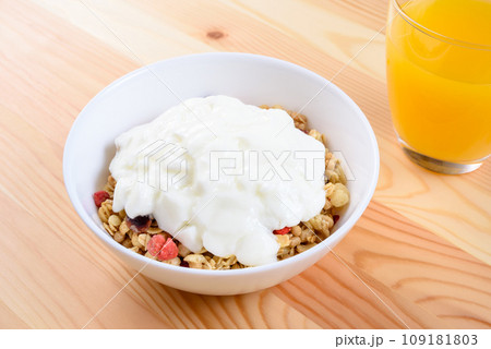 白い皿に入ったシリアルとヨーグルト　フルーツグラノーラ　朝食　健康食品　テーブル 109181803