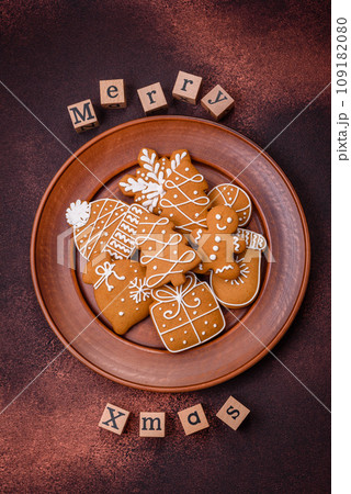 Beautiful delicious sweet winter Christmas gingerbread cookies on a bronze textured background Beautiful delicious sweet winter Christmas gingerbread cookies on a bronze textured background 109182080