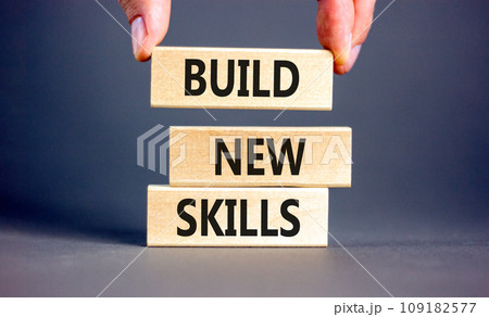 Build new skills symbol. Concept word Build new skills on beautiful wooden block. Businessman hand. Beautiful grey table grey background. Business, education build new skills concept. Copy space. 109182577