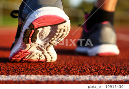 Woman running on athletic track Woman running on athletic track 109184304