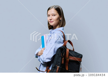 Portrait of young university female student on gray background 109184434