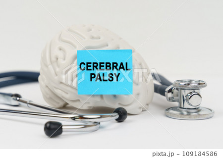 On a white surface next to the stethoscope lies a brain on which a sticker with the inscription - CEREBRAL PALSY On a white surface next to the stethoscope lies a brain on which a sticker with the inscription - CEREBRAL PALSY 109184586